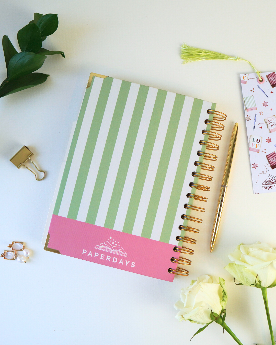 Gratitude journal, wellness journal and moon-and-stars journal by PaperDays in soft pastels, photographed with a candle.