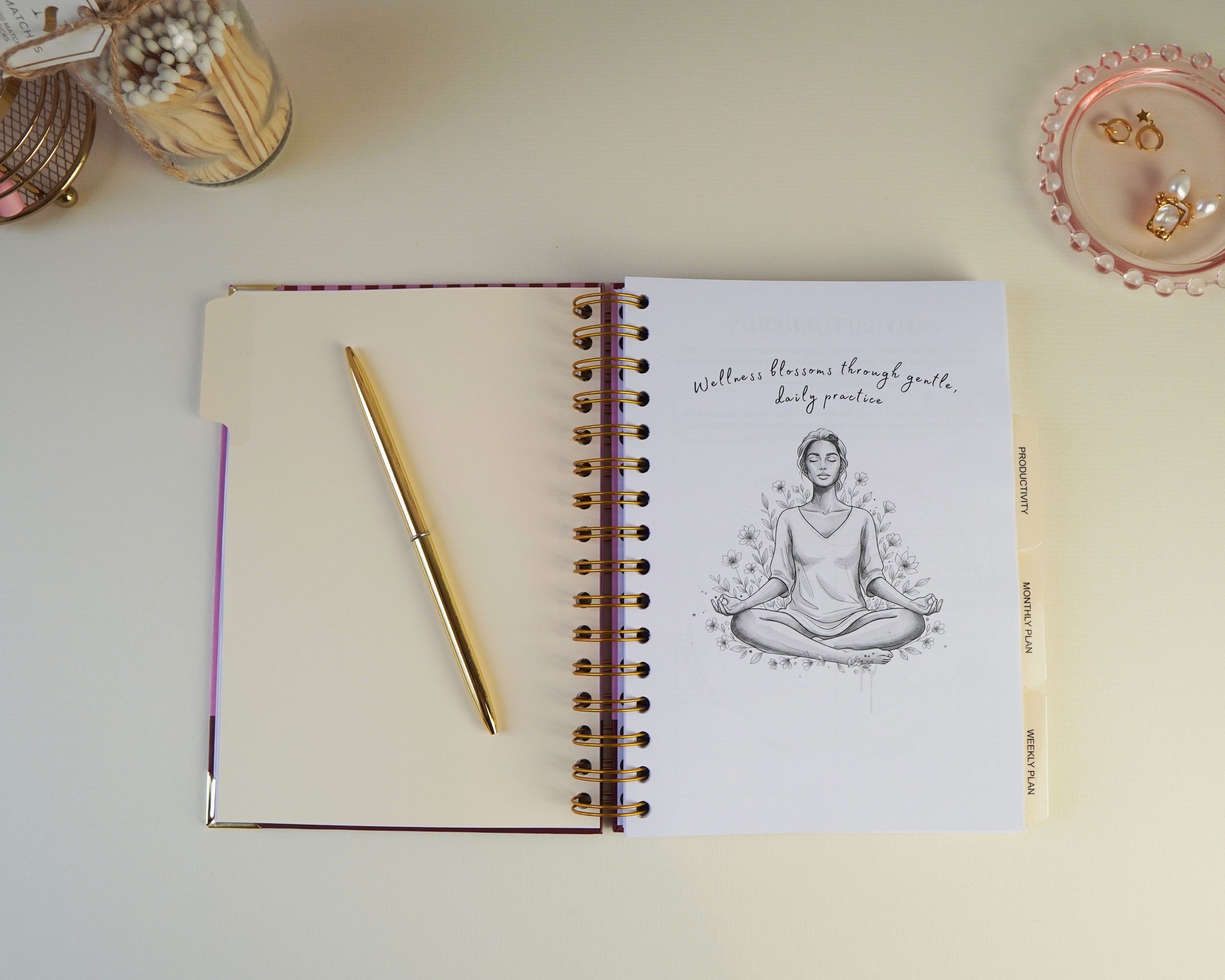 Open notebook with a meditation illustration on a light surface with decorative items.